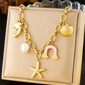 Gold-tone multi-pendant necklace with dolphin, pearl, starfish and shell and cloud charms