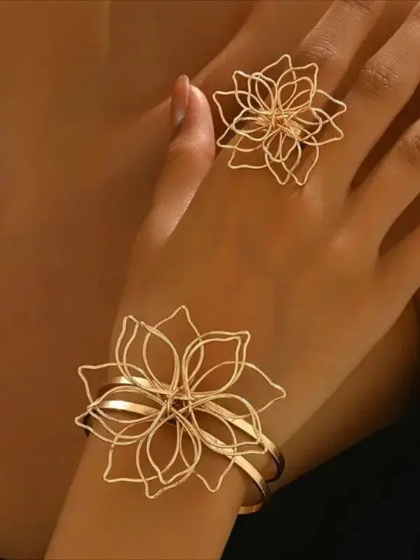 Gold-tone openwork hollow flower bracelet cuff and ring on hand, matching blossoms