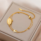 Gold-tone bracelet with oval Virgin Mary pendant, cross charm, and layered chain links