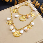Gold-tone ocean charm necklace with scallop shell pendant, turtle charm, dangling pearl clusters