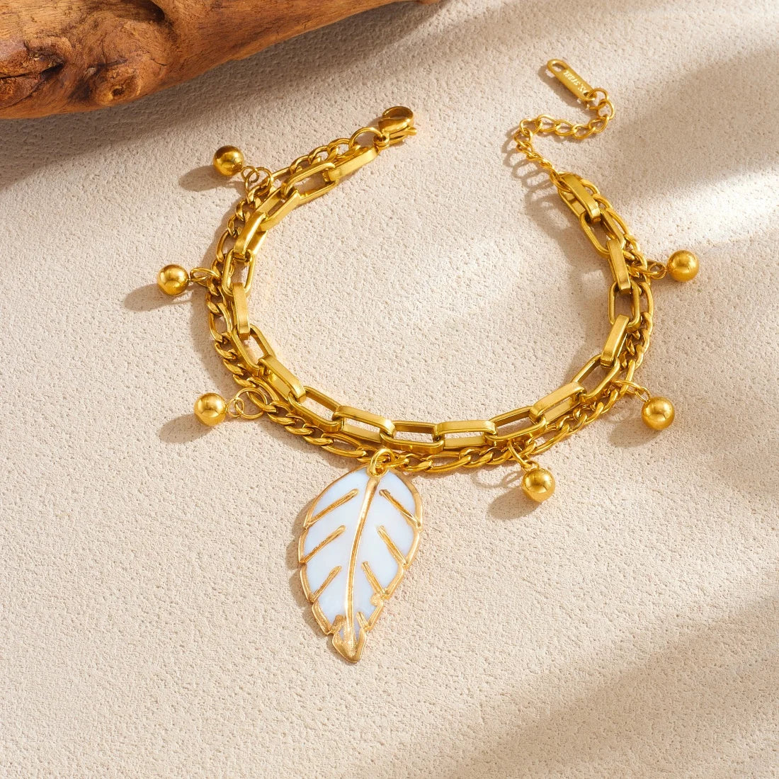 Gold double-layer chain bracelet with large leaf charm and bead tassels