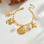 Gold-tone ocean charm necklace with scallop shell pendant and sea turtle, crab charms, pearl drops