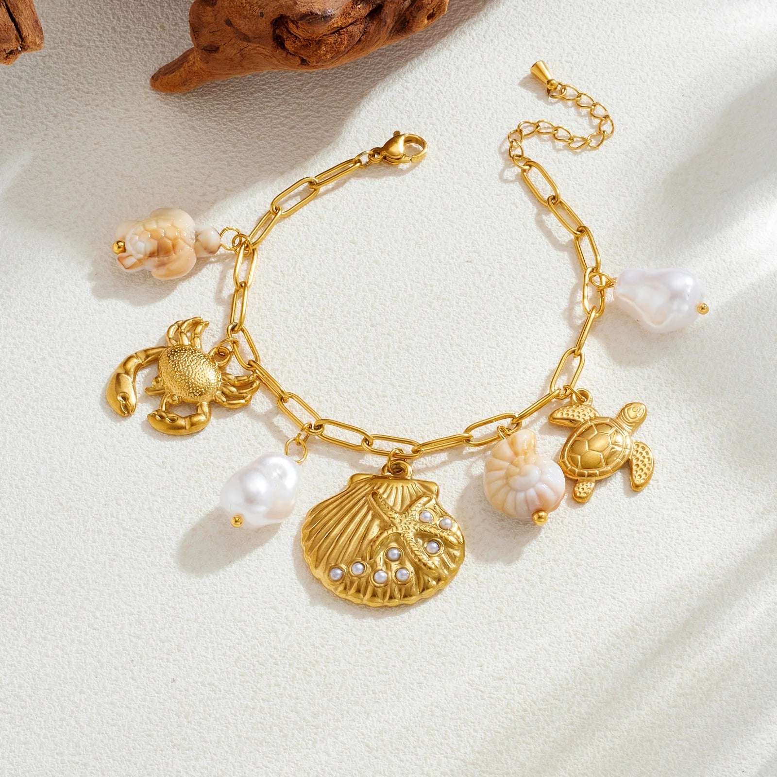 Gold-tone ocean charm necklace with scallop shell pendant and sea turtle, crab charms, pearl drops