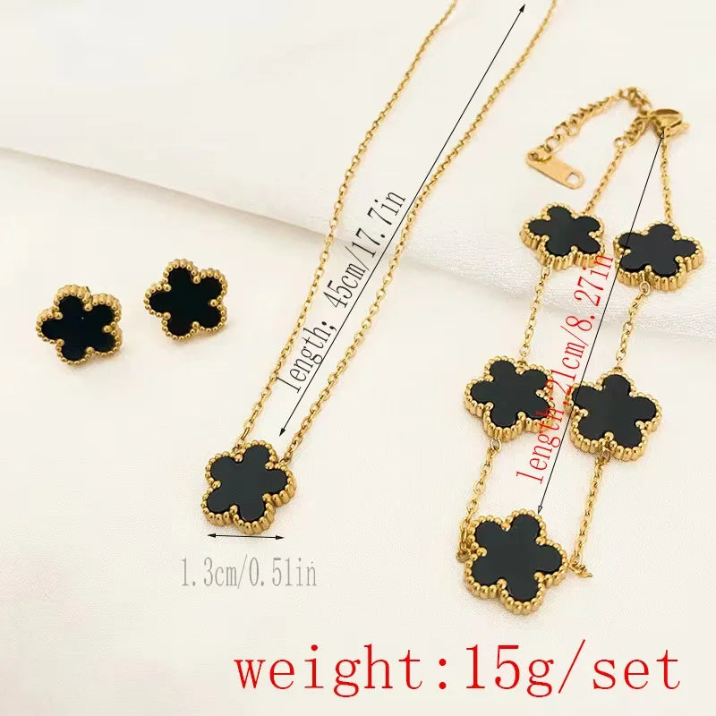 Gold-tone clover jewelry set with black enamel necklace, bracelet, and stud earrings