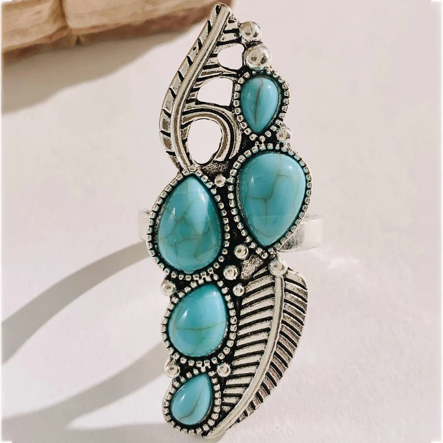 Turquoise cabochon boho ring with ornate cutout band and silver-tone detailing