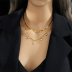 Gold-tone double-layer snake chain necklace with blue evil-eye charms and small beads