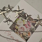 Silver-tone starfish waist belly chain on a jewelry display card with starfish charms