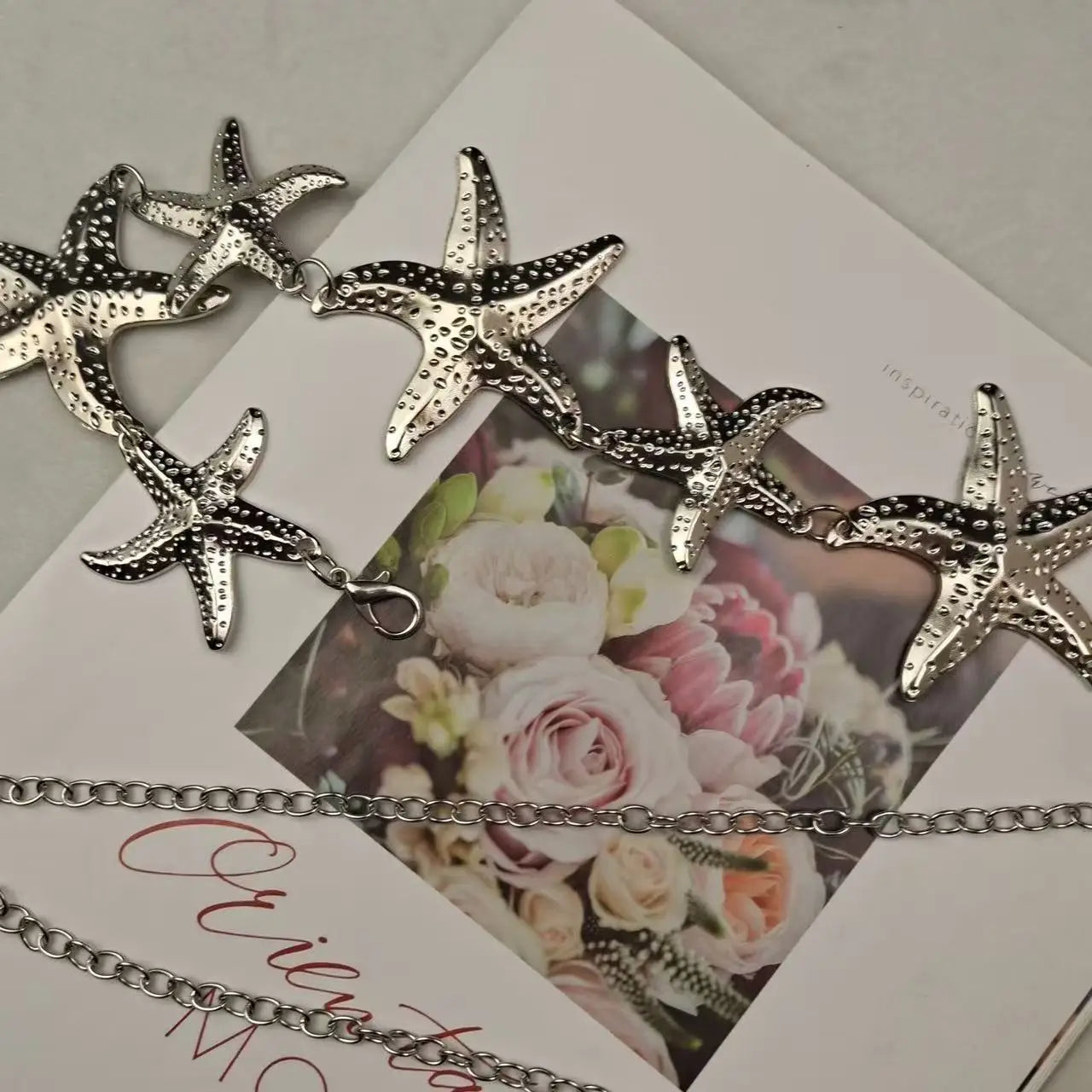 Silver-tone starfish waist belly chain on a jewelry display card with starfish charms