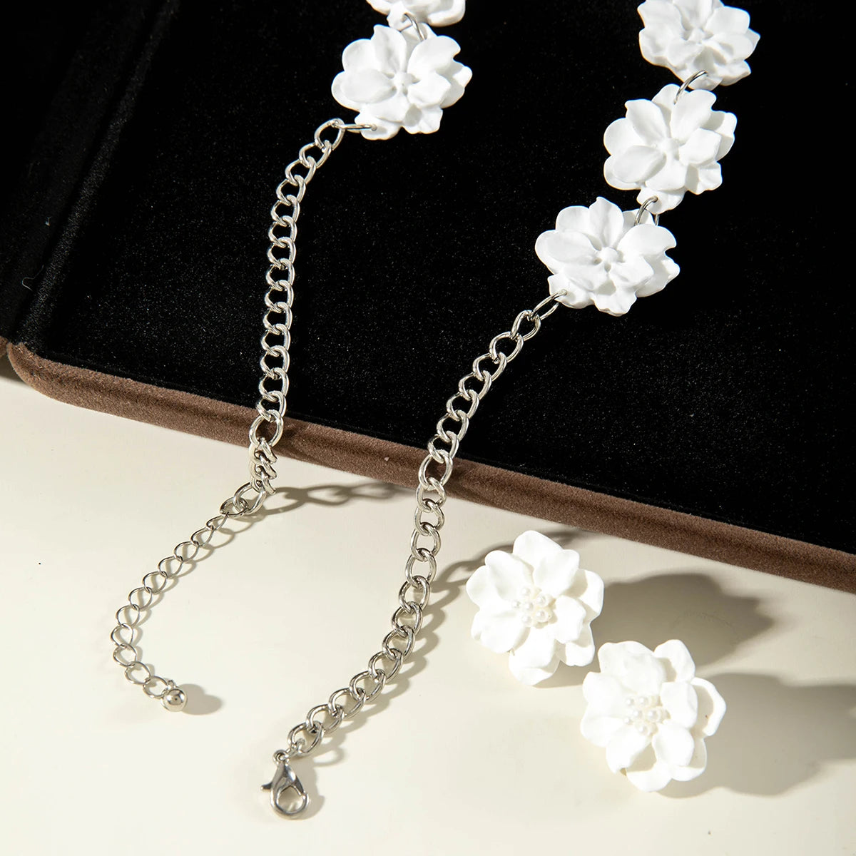 White flower earrings with silver-tone hooks and matching necklace chain