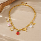 Gold tone ladybug, butterfly, flower and pearl charm necklace