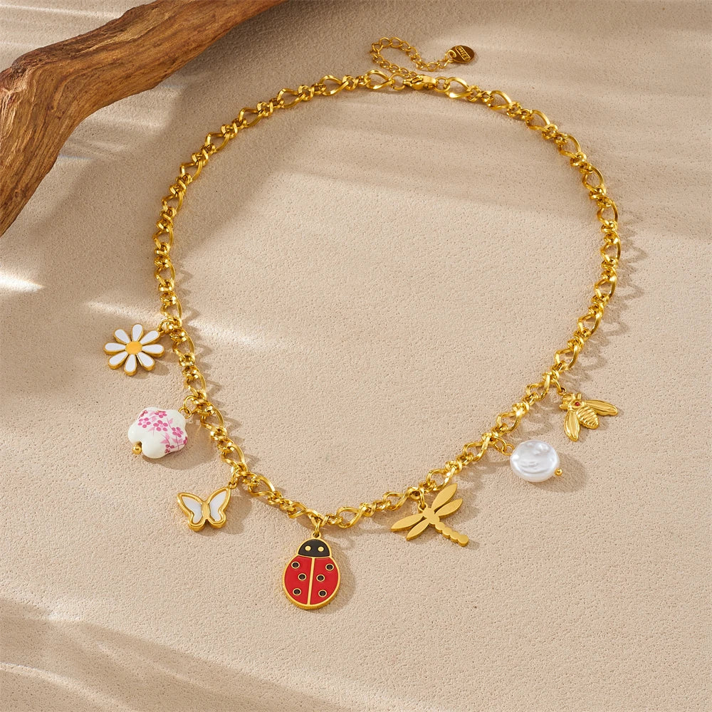Gold tone ladybug, butterfly, flower and pearl charm necklace