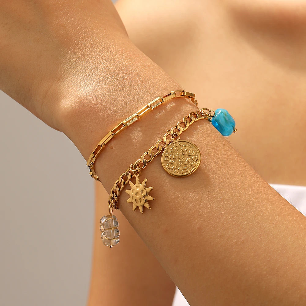Gold-tone double-layer bracelet with sun, heart, coin charms and turquoise bead