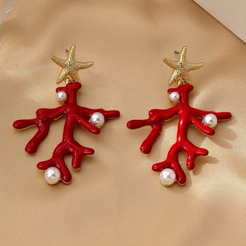 Pair of coral starfish earrings with red enamel, gold-tone starfish, and pearl-like beads