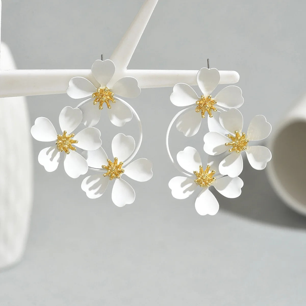 White camellia-style flower dangle earrings with gold-tone star centers and round hoop drops
