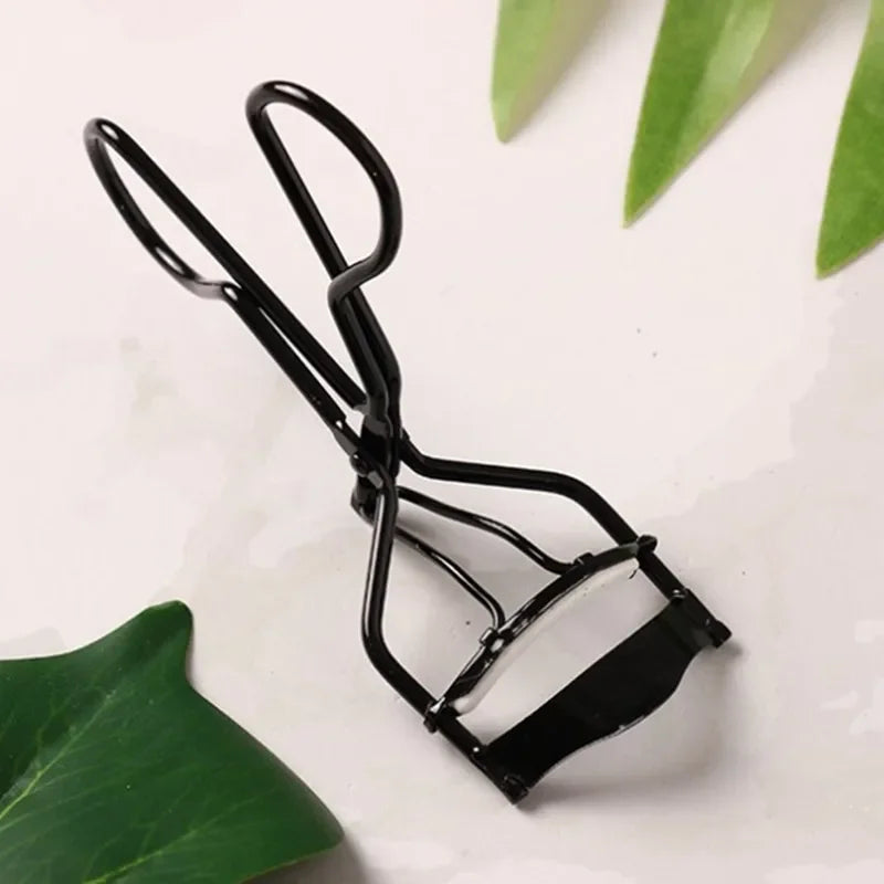 Black eyelash curler tool with spring arms and angled pad plate