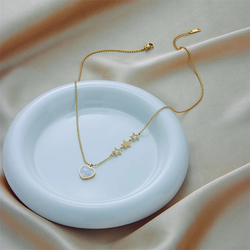 Gold-tone heart and star pendant necklace with small heart charm