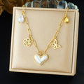 Gold-tone heart pendant necklace with pearl accents, butterfly charm, and flower pendants