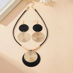 Round statement earrings set with four layered round discs in gold and black on hooks