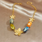 Gold-tone flower charm necklace with multicolor resin oval beads and linked chain