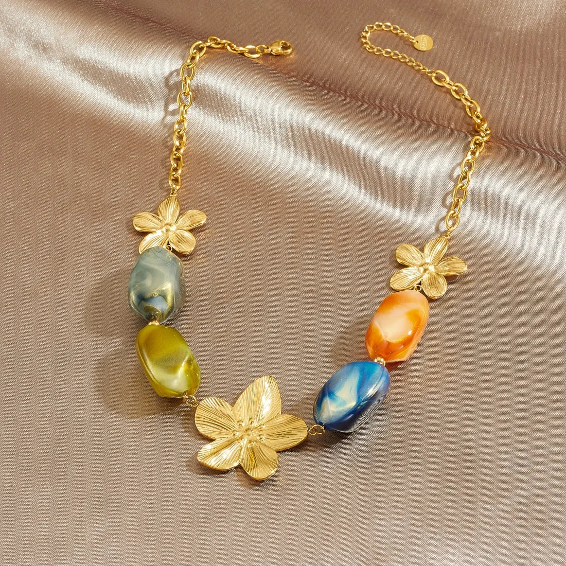 Gold-tone flower charm necklace with multicolor resin oval beads and linked chain