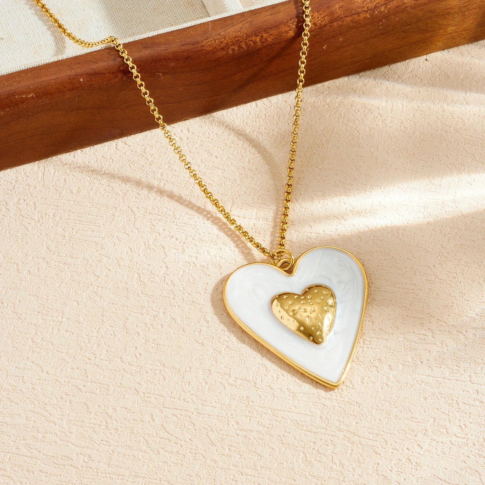 Gold chain necklace with white enamel heart pendant and gold inner heart