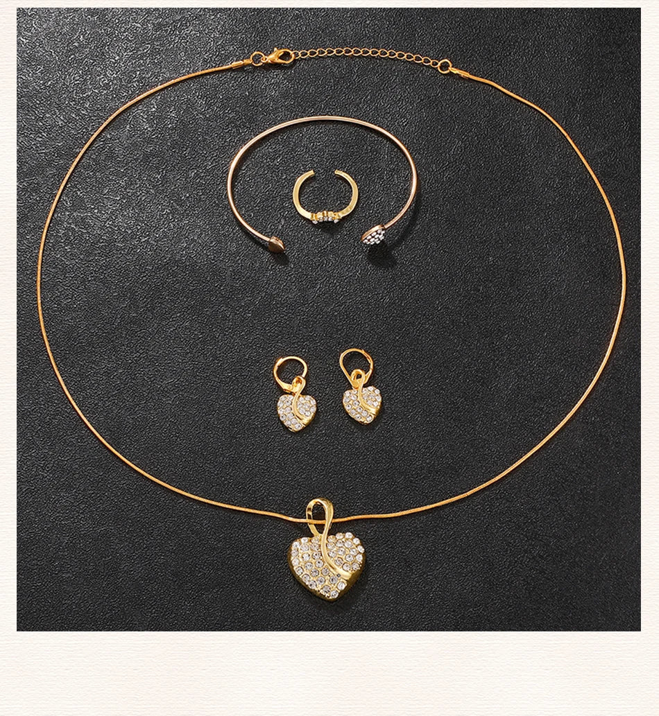 Gold heart pendant necklace with rhinestone details; matching hoop earrings and bangle ring