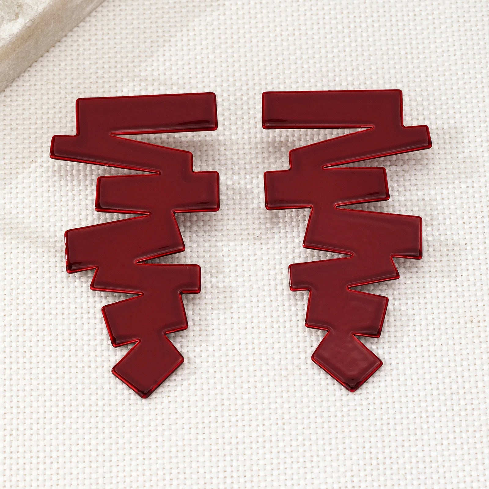 Geometric stud earrings in red with flat, layered zigzag blocks and pointed ends