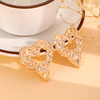 Gold heart-shaped drop earrings with ornate raised texture, pair