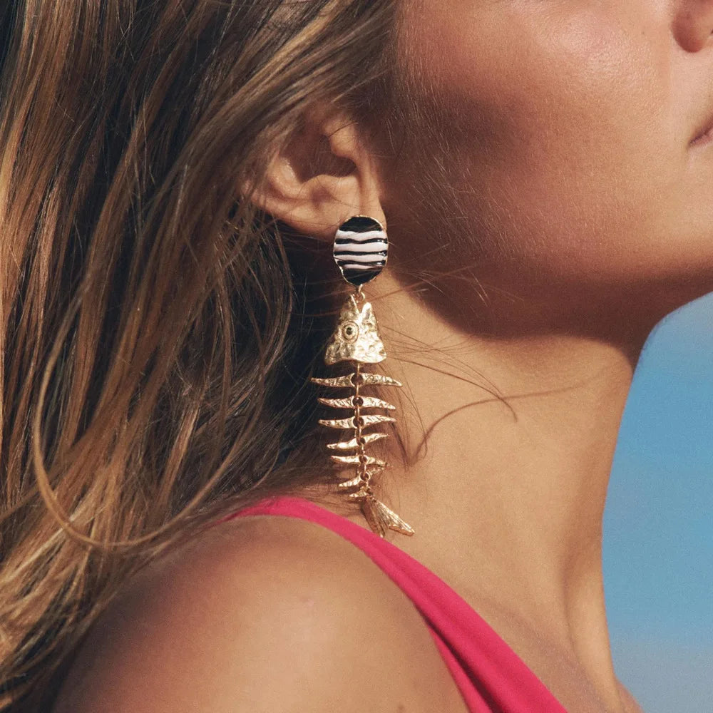 Striped black-and-white fishbone dangle earrings with gold-tone skeleton drop