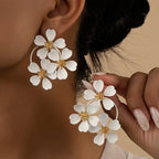 White camellia-style flower dangle earrings with gold-tone star centers and hoop links