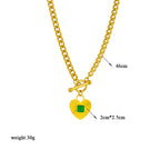 Gold-tone chain necklace featuring a green square stone heart charm and toggle clasp