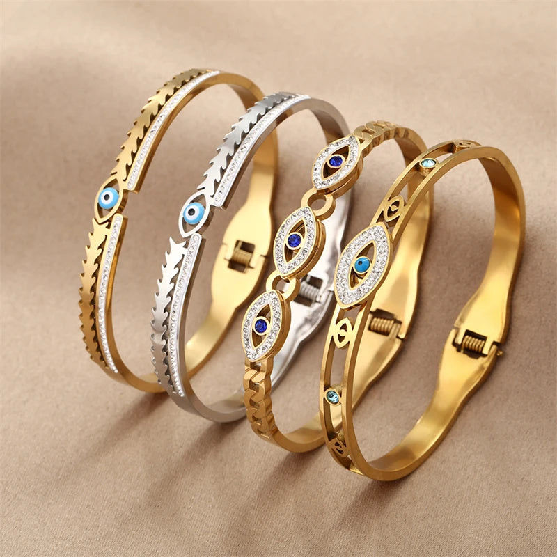 Stacked gold and silver-toned evil-eye bangles with blue enamel and crystal accents