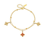 Gold-tone flower charm bracelet with red center pendant and four white crystal flower charms