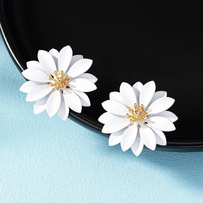 White enamel flower stud earrings with gold-tone starburst centers