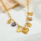Gold-tone multi-pendant necklace with small tassel and heart charms, some with blue enamel