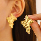 Wrinkled oval drop earrings, gold tone, glossy textured oval shapes.