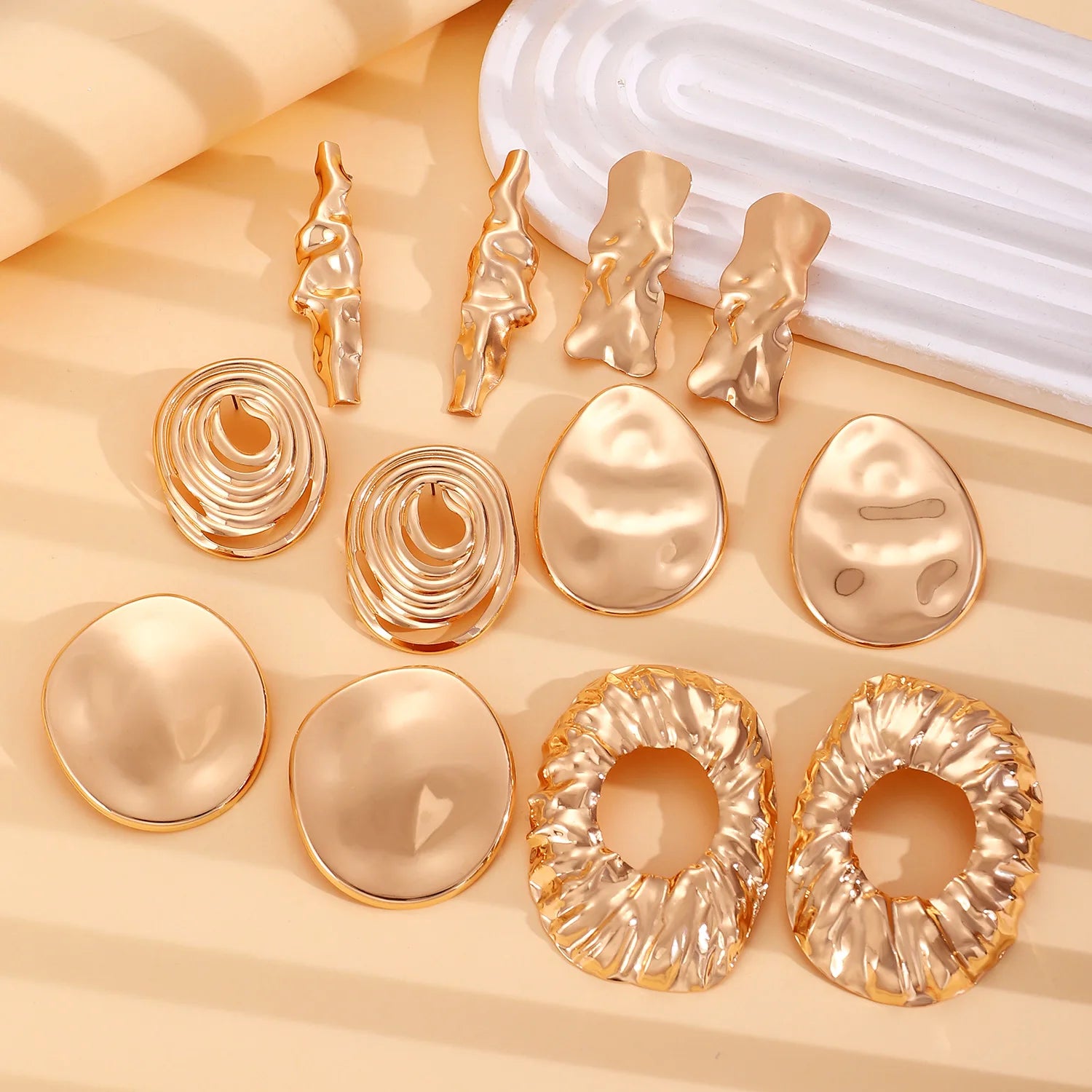 Assorted metal earrings with round pendants and hoop loops in gold and silver