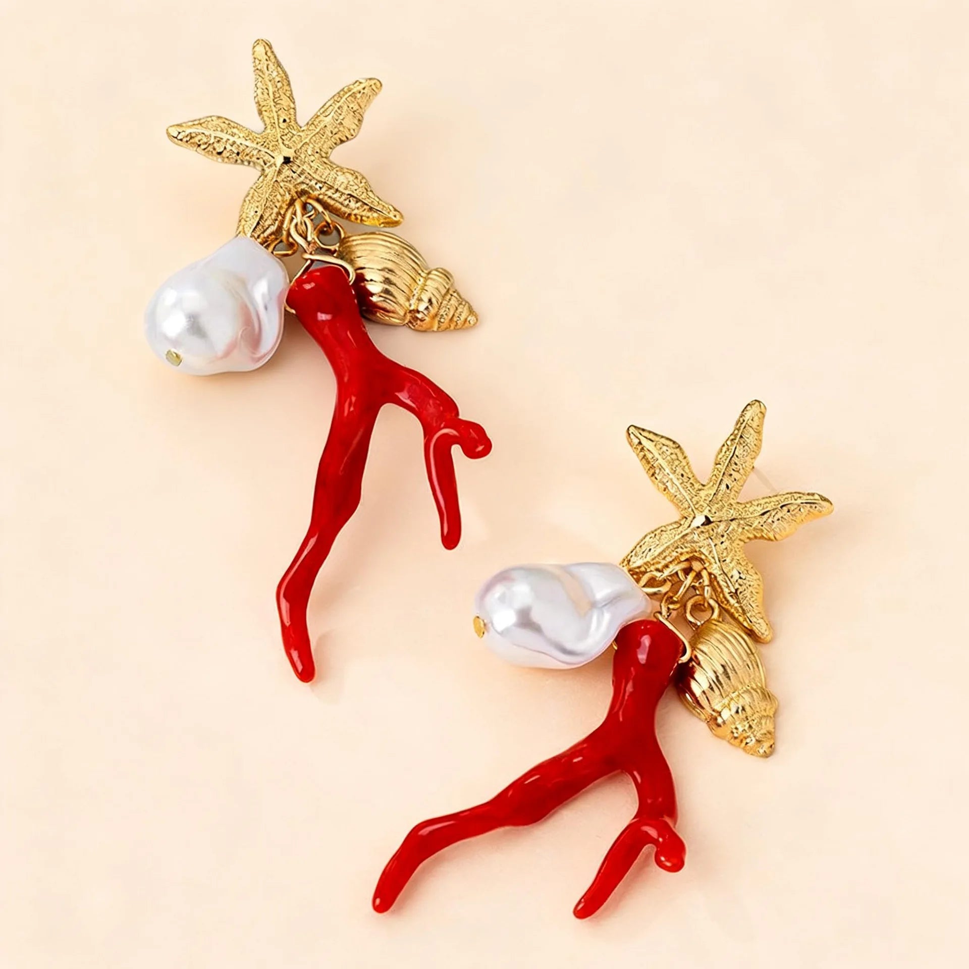 Pair of star-and-figure resin earrings with red bodies, white pearls, gold-tone accents