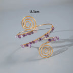 Gold-tone upper arm bracelet set with spiral wire and purple and clear stone beads