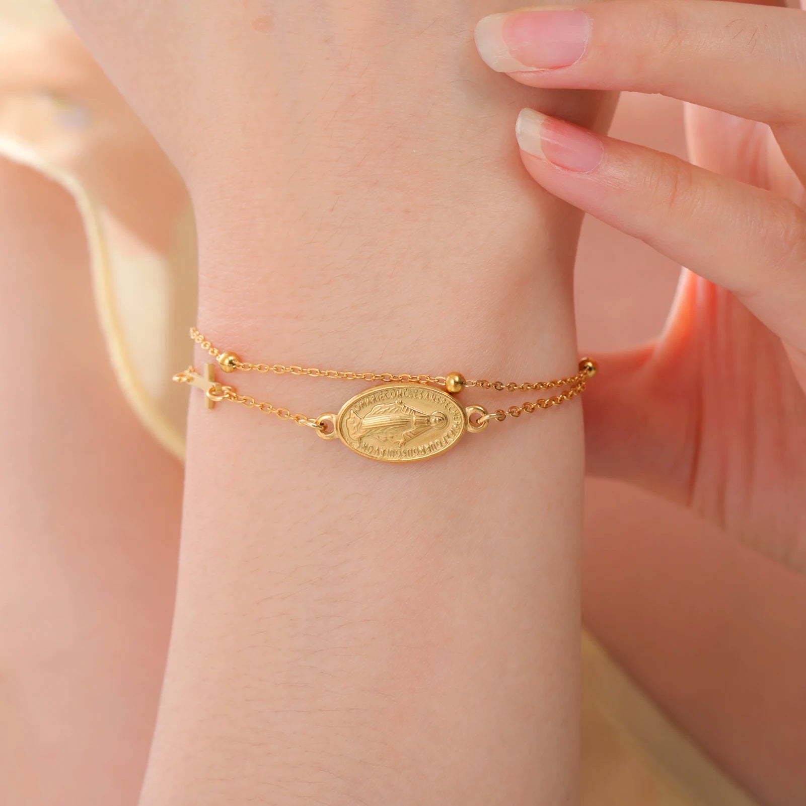 Gold-tone pendant bracelet with oval Virgin Mary medallion and small cross charms on chain