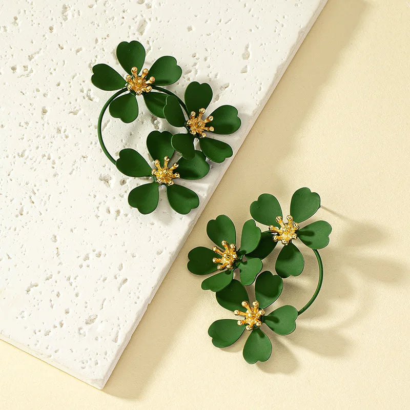 Green camellia-style flower dangle earrings with gold-tone star centers and hoop drops