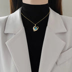 Gold-tone crescent moon pendant necklace with blue rhinestone center