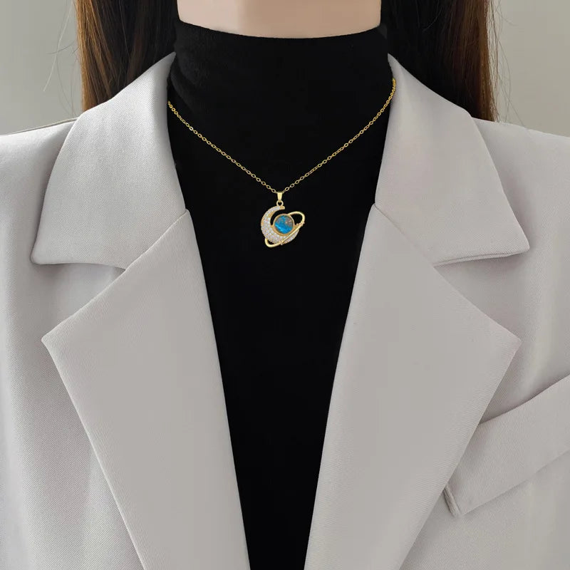 Gold-tone crescent moon pendant necklace with blue rhinestone center