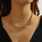 Watermelon enamel charm necklace with gold-tone chain, red-green pendants, and small stones