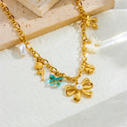 Gold-tone multi-pendant necklace with butterfly, heart, and turquoise bead charm