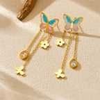 Pair of butterfly tassel earrings with blue enamel wings, gold flower charms, and crystal drops
