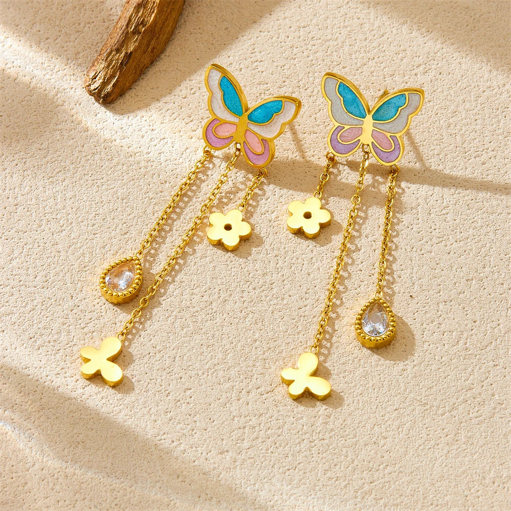 Pair of butterfly tassel earrings with blue enamel wings, gold flower charms, and crystal drops