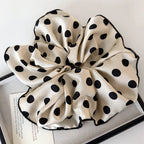 Polka dot cream scrunchie with a large fabric bow and elastic gathered center