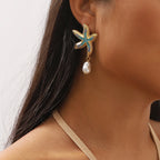 Starfish drop earrings on model: gold-tone blue and turquoise crystals with white pearl dangle