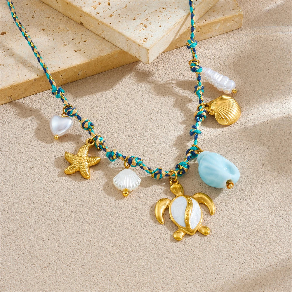 Sea turtle, starfish, and shell pendants on turquoise beaded necklace with white accents
